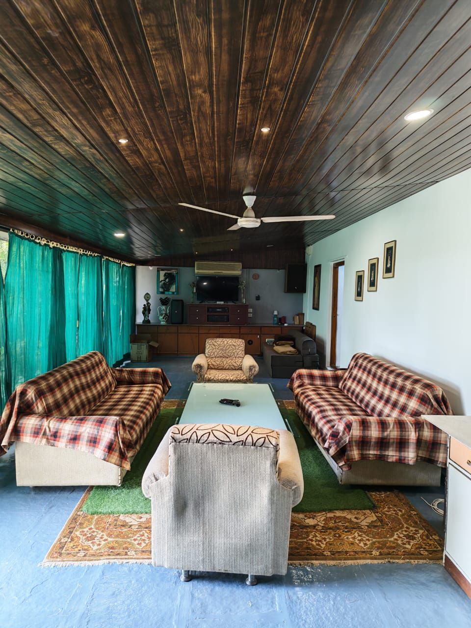 Living room with sofas, a rug and a wooden ceiling